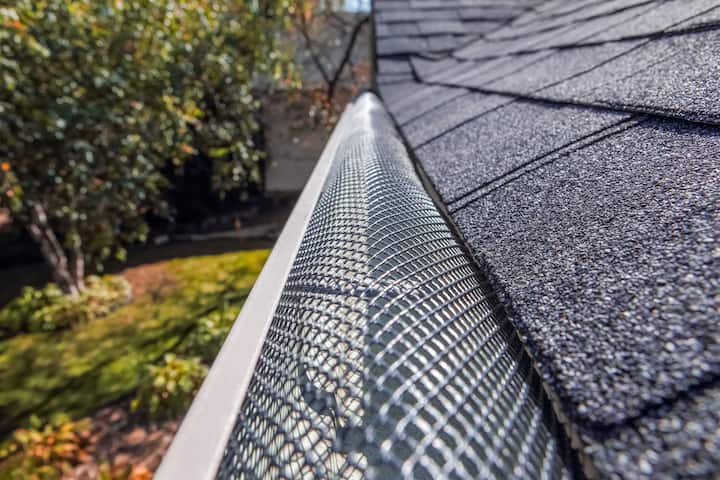 A contractor demonstrating the effectiveness of a gutter guard to a potential client in Vienna